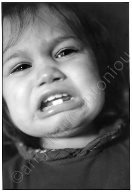 A crying toddler close to the camera, tears on both cheeks